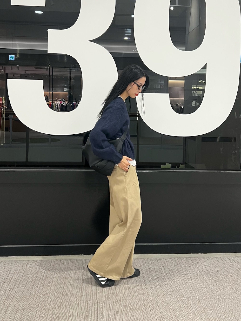 ベージュ系のその他パンツ、ブルー系のニット/セーター、ホワイト系のTシャツ/カットソーを着用したレディースの秋コーディネートの2枚目の写真