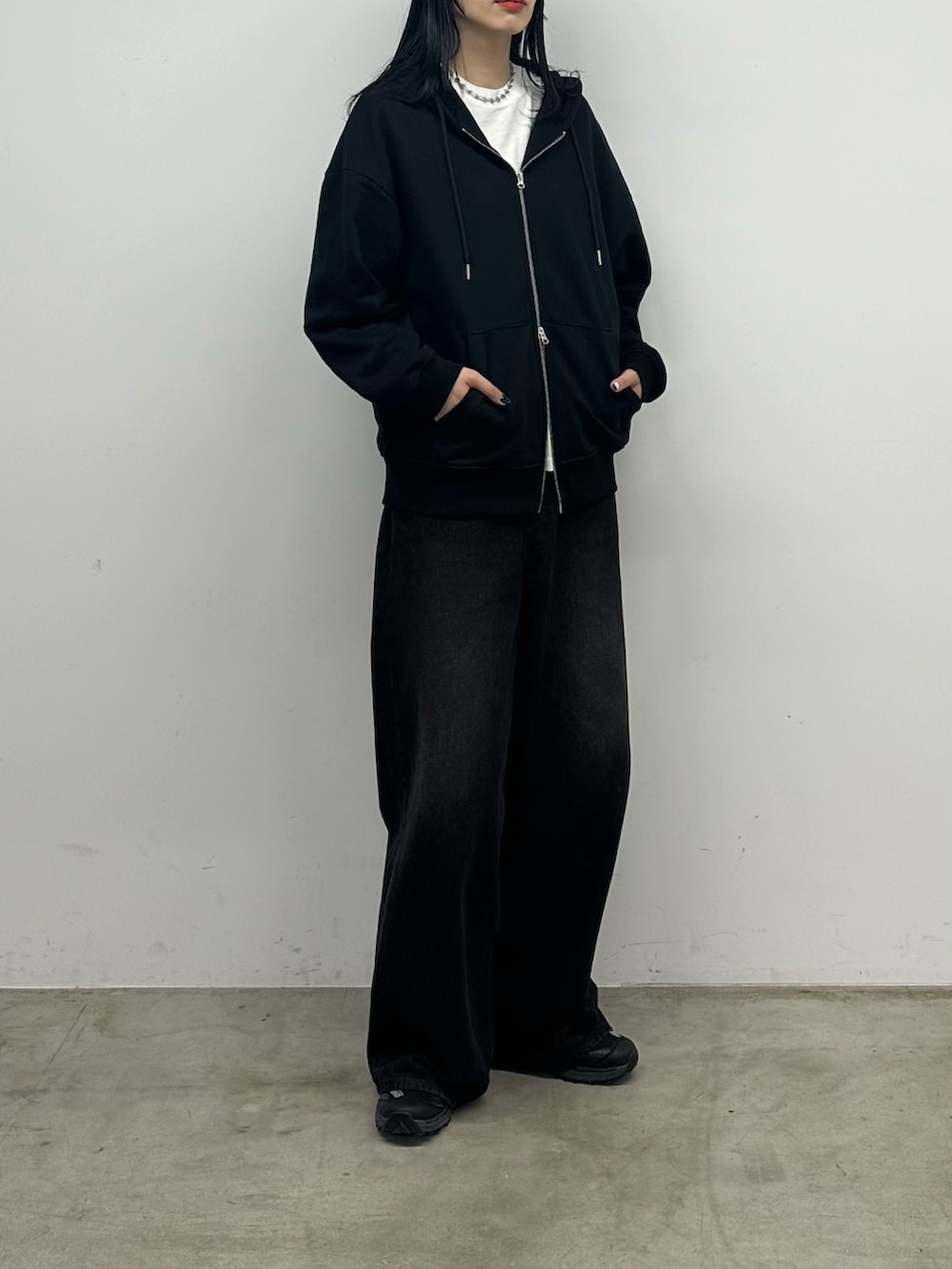 ブラック系のデニムパンツ、ブラック系のパーカーを着用したレディースの秋コーディネートの2枚目の写真
