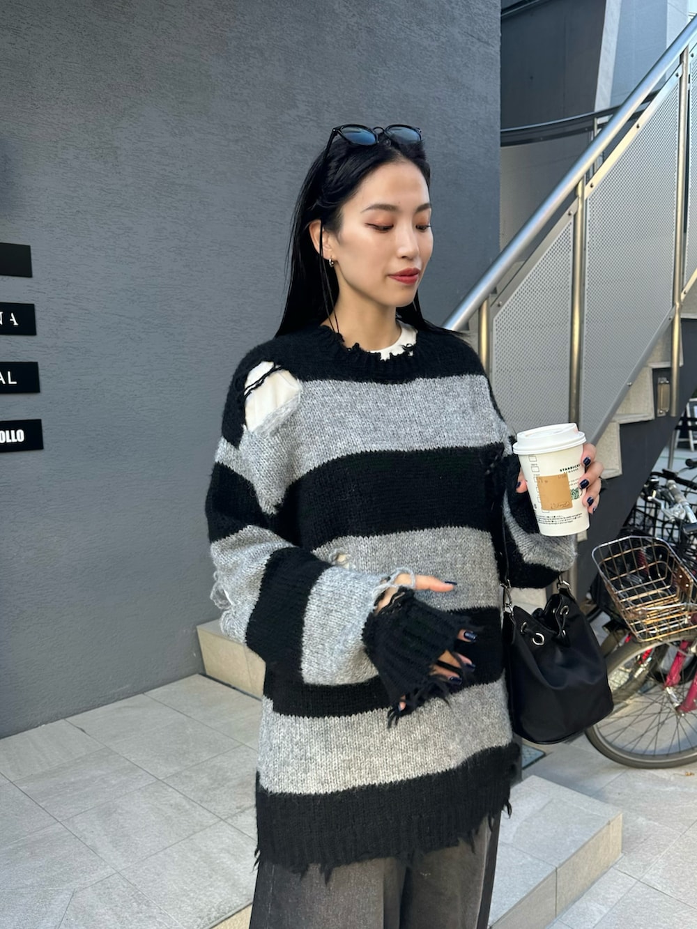 ブラック系のニット/セーター、ブラック系のデニムパンツを着用したレディースの秋コーディネートの3枚目の写真