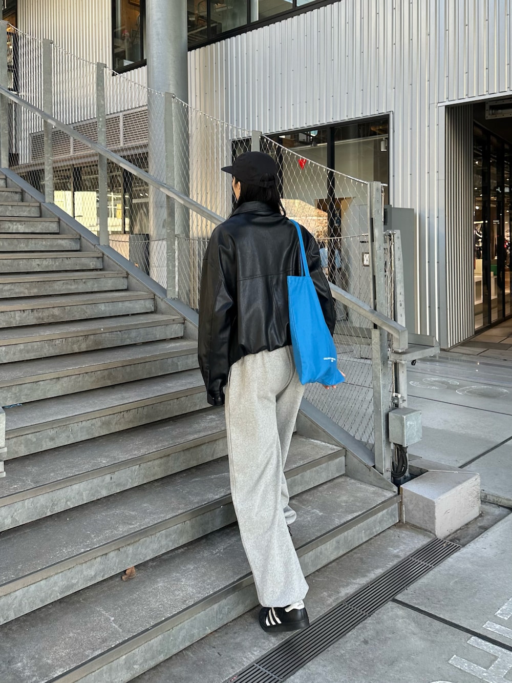 ブラック系のブルゾン、ブルー系のトートバッグを着用したレディースの冬コーディネートの3枚目の写真