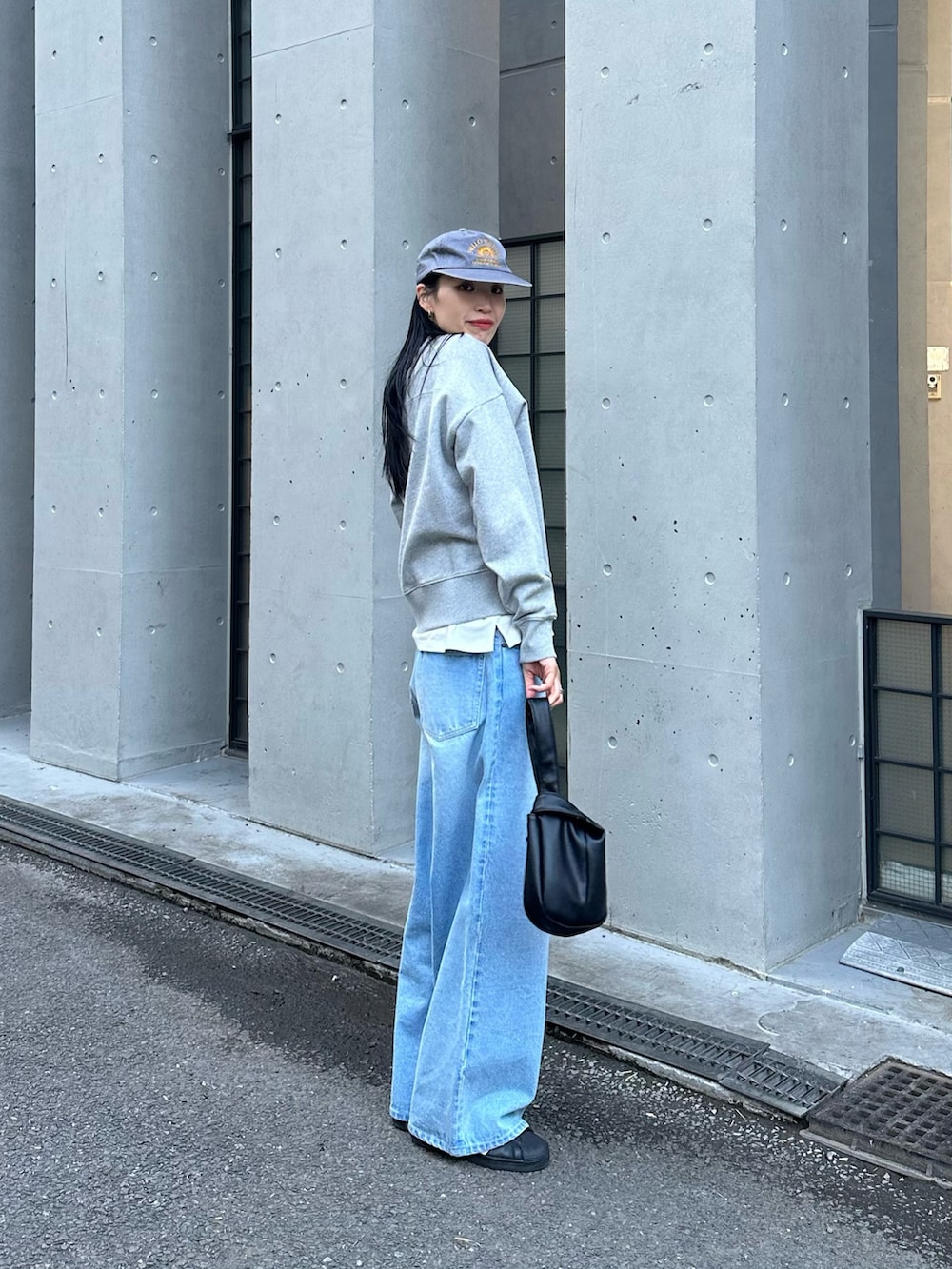 ブルー系のデニムパンツ、ブラック系のハンドバッグを着用したレディースの冬コーディネートの2枚目の写真