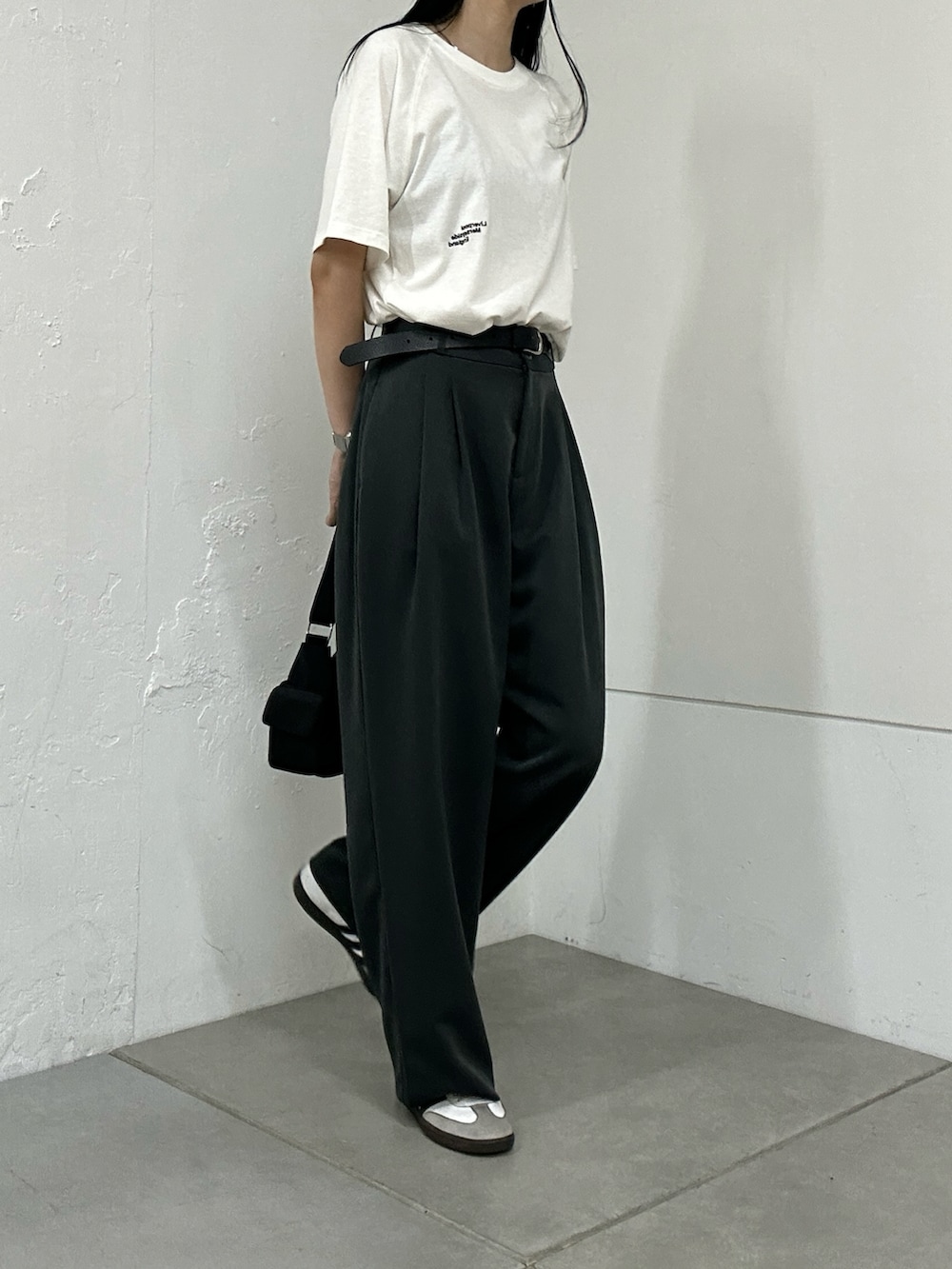 ホワイト系のTシャツ/カットソー、グレー系のスラックス、ブラック系のショルダーバッグを着用したレディースの夏コーディネートの2枚目の写真