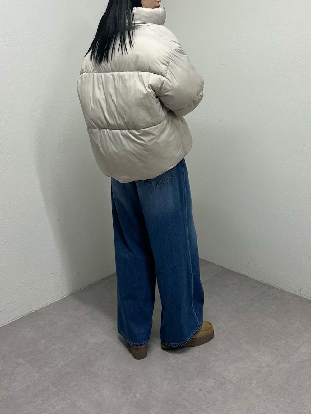 ベージュ系のダウンジャケット/コート、ブルー系のデニムパンツ、ベージュ系のモカシン/デッキシューズを着用したレディースの冬コーディネートの4枚目の写真