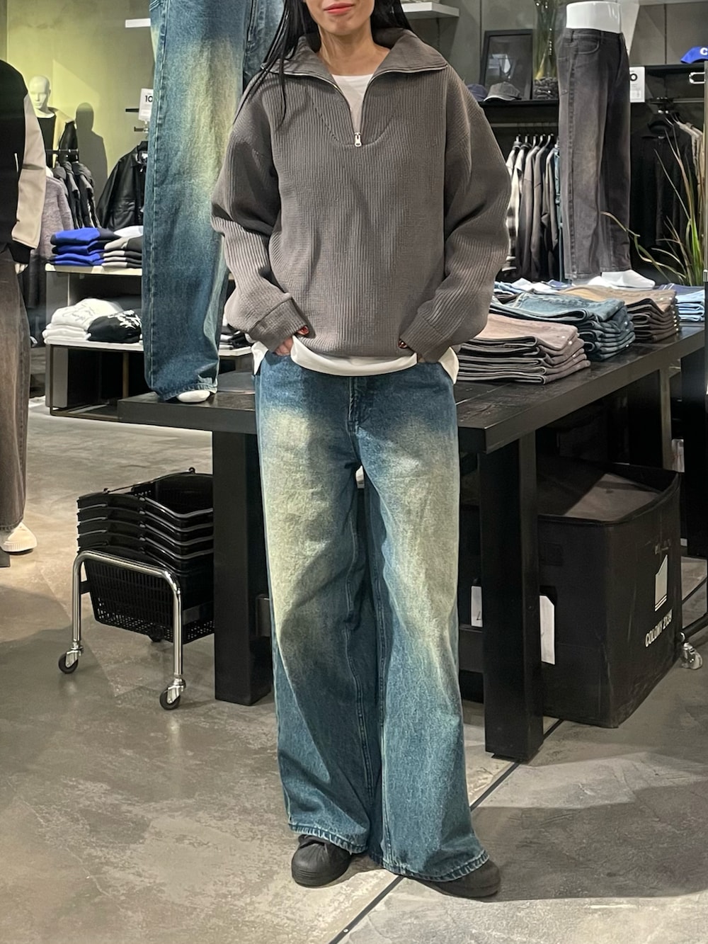 グレー系のニット/セーター、ホワイト系のTシャツ/カットソー、ブルー系のデニムパンツを着用したレディースの冬コーディネートの4枚目の写真