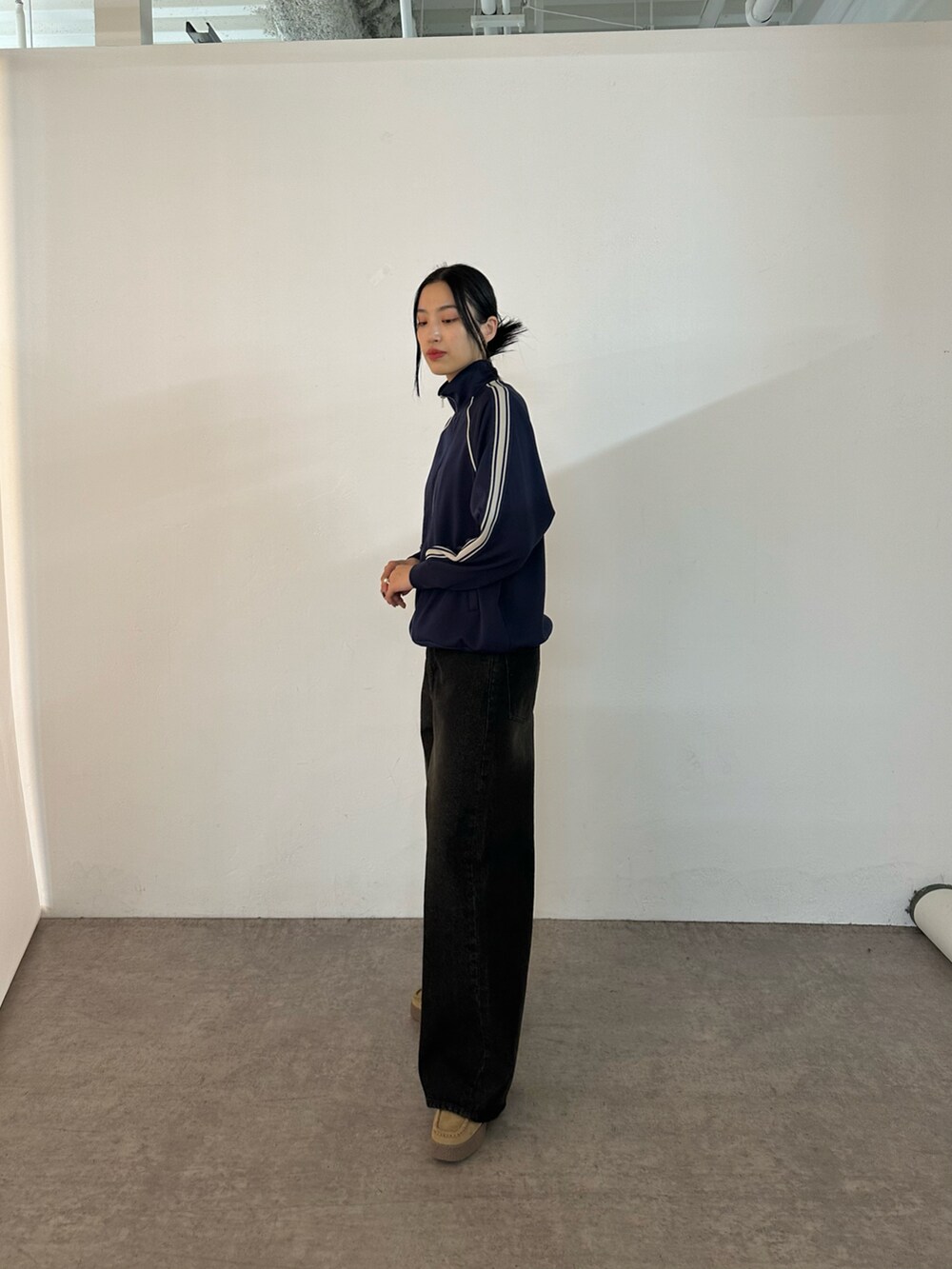 ブラック系のデニムパンツ、ブルー系のジャケット/アウター、ベージュ系のモカシン/デッキシューズを着用したレディースの冬コーディネートの2枚目の写真