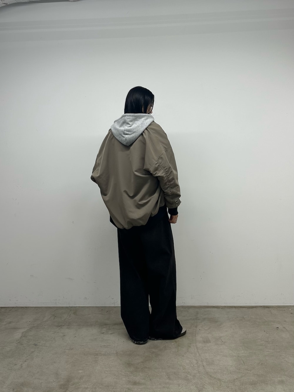 ブラック系のニット/セーター、グレー系のパーカー、ベージュ系のジャケット/アウターを着用したレディースの秋コーディネートの3枚目の写真