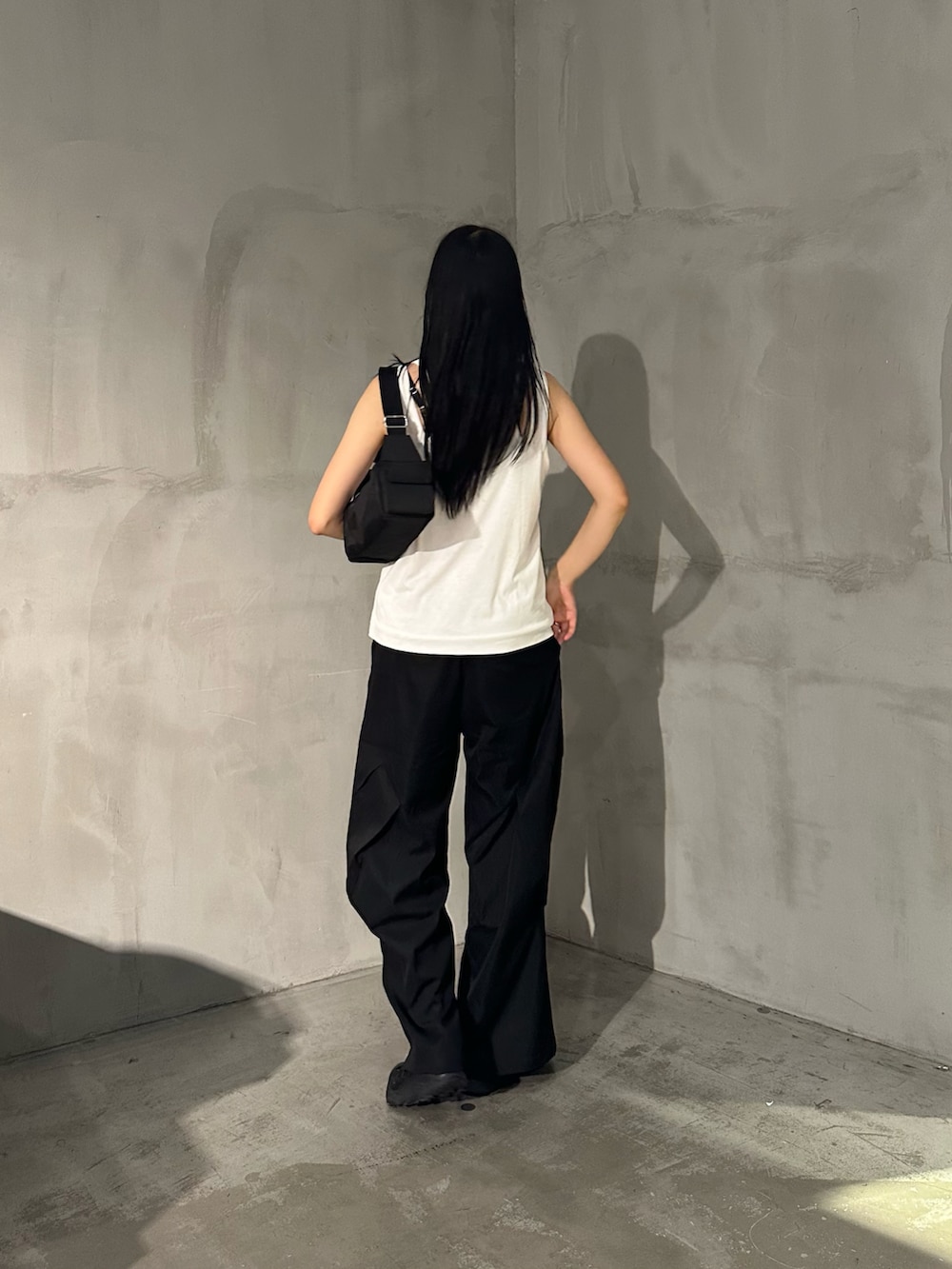 ホワイト系のタンクトップ、ブラック系のその他パンツ、ブラック系のショルダーバッグを着用したレディースの夏コーディネートの3枚目の写真