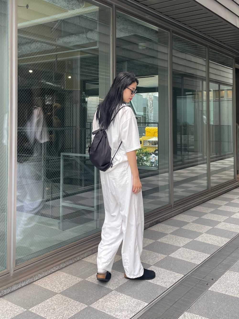 ホワイト系のTシャツ/カットソー、ブラック系のバックパック/リュック、ホワイト系のその他パンツを着用したレディースの夏コーディネートの4枚目の写真