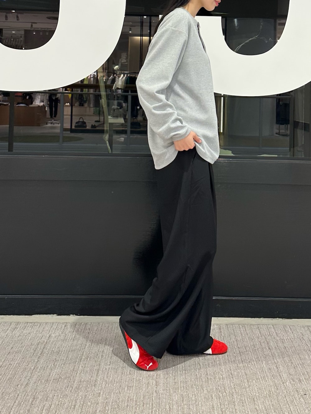 グレー系のTシャツ/カットソー、ブラック系のスラックス、ブラック系のキャップを着用したレディースの春コーディネートの2枚目の写真