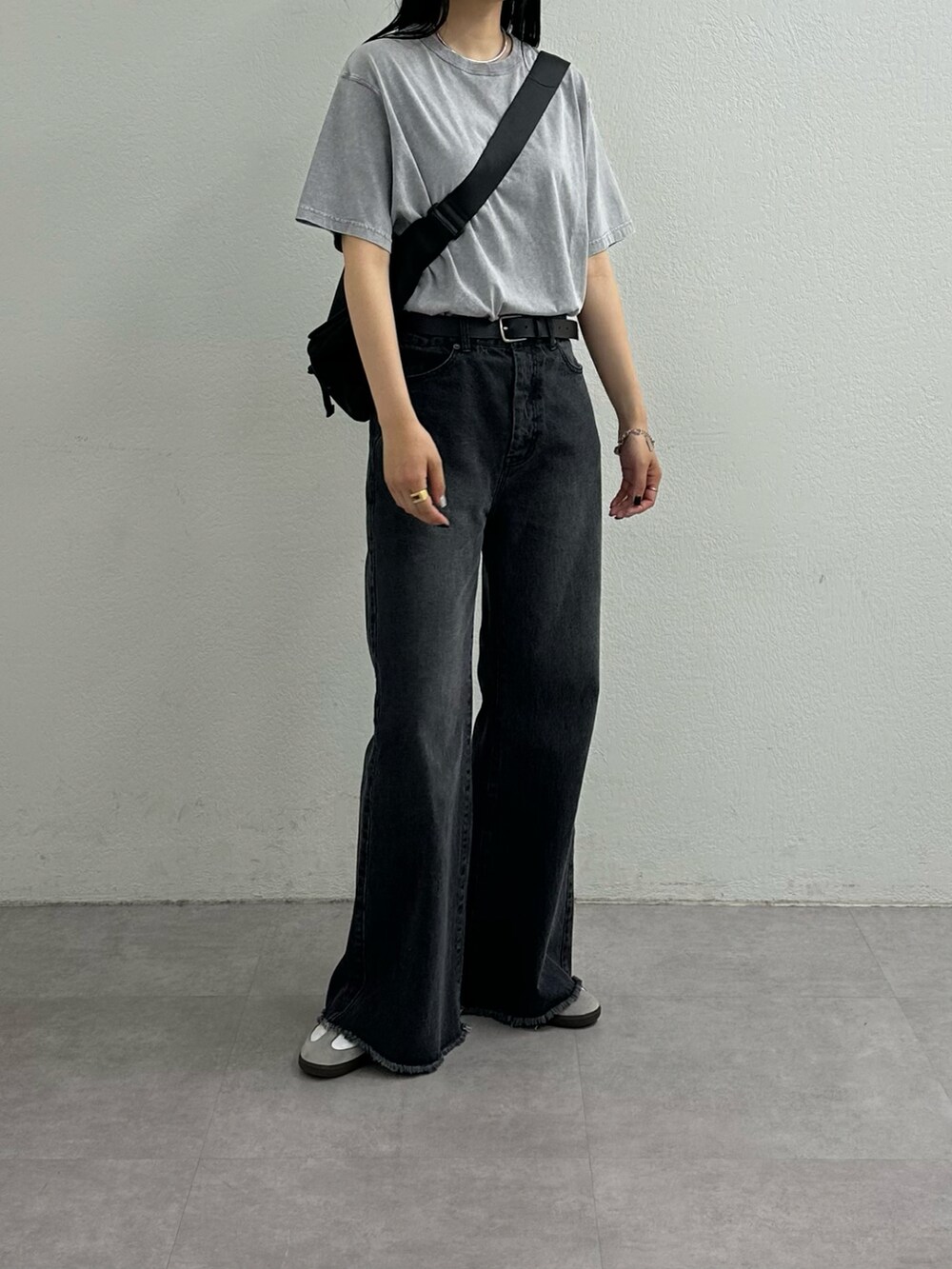 ブラック系のデニムパンツ、グレー系のTシャツ/カットソー、ブラック系のショルダーバッグを着用したレディースの夏コーディネートの3枚目の写真