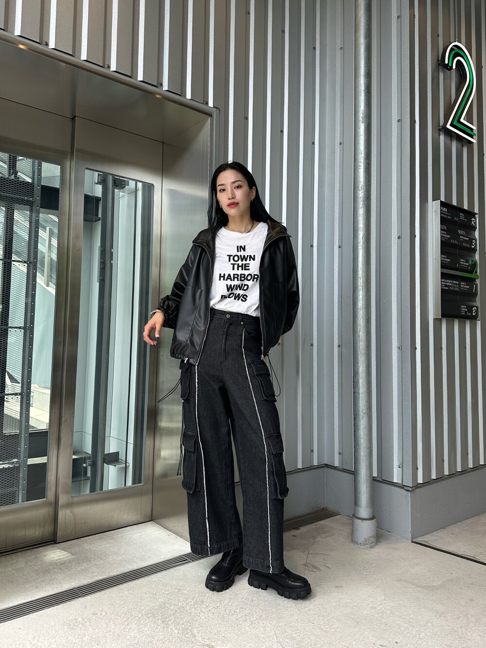 ブラック系のブルゾン、ブラック系のデニムパンツ、ホワイト系のTシャツ/カットソーを着用したレディースの夏コーディネートの2枚目の写真