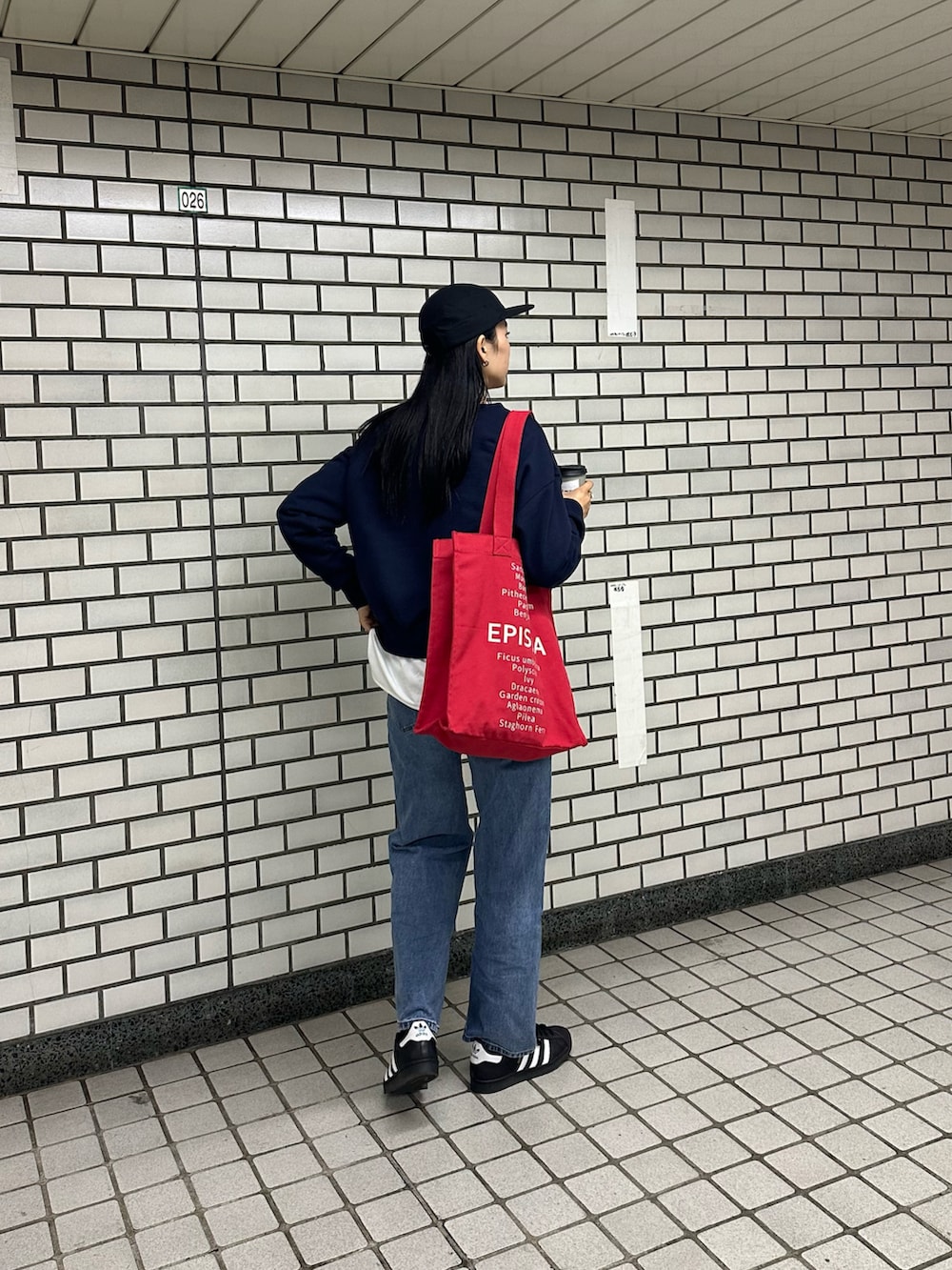 ブルー系のスウェット、レッド系のトートバッグ、ホワイト系のTシャツ/カットソーを着用したレディースの春コーディネートの3枚目の写真