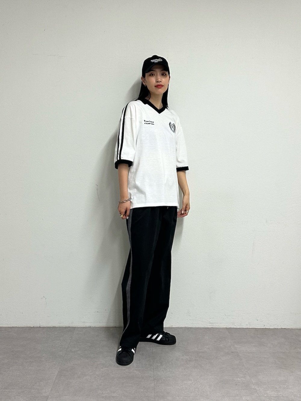 ブラック系のその他パンツ、ホワイト系のTシャツ/カットソー、ブラック系のキャップを着用したレディースの春コーディネートの2枚目の写真