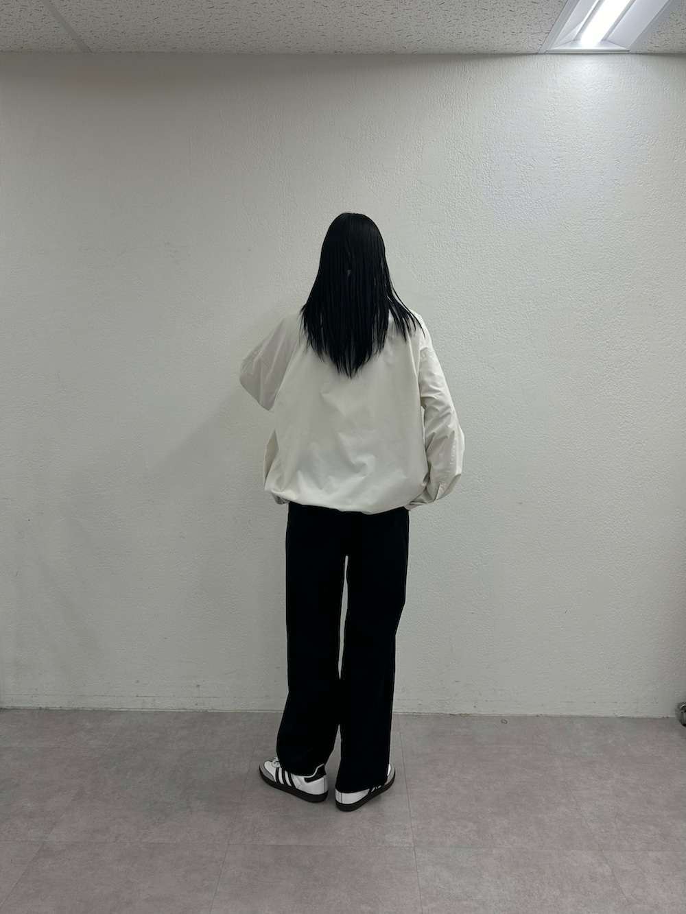 ホワイト系のブルゾン、ブラック系のその他パンツを着用したレディースの冬コーディネートの3枚目の写真