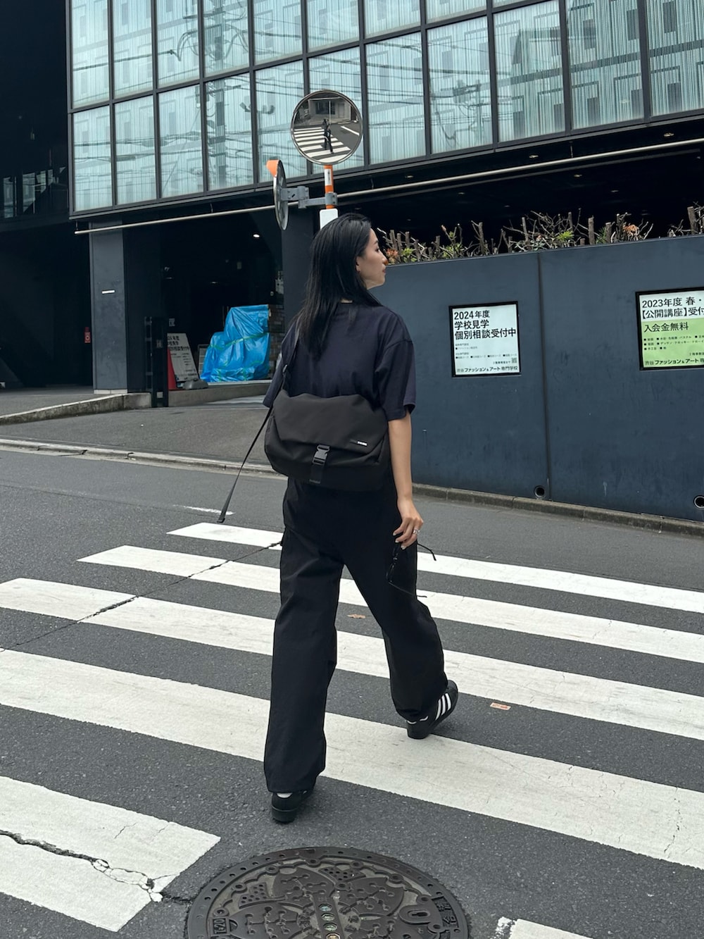 ブラック系のカーゴパンツ、ブラック系のメッセンジャーバッグ、ブルー系のTシャツ/カットソーを着用したレディースの夏コーディネートの2枚目の写真