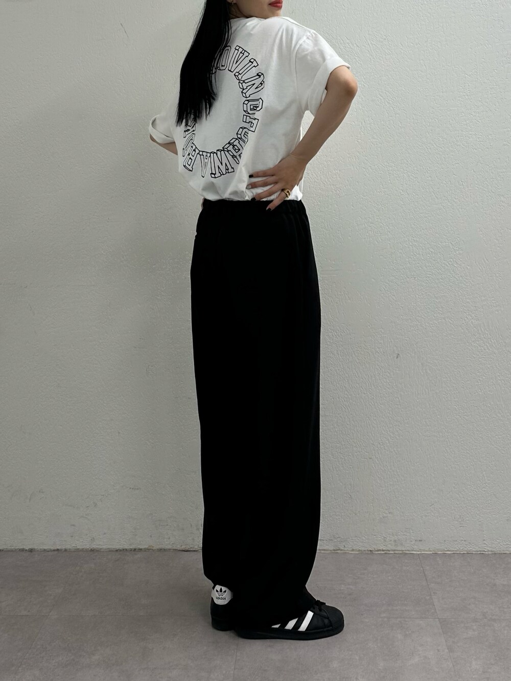 ブラック系のスラックス、ホワイト系のTシャツ/カットソーを着用したレディースの夏コーディネートの3枚目の写真
