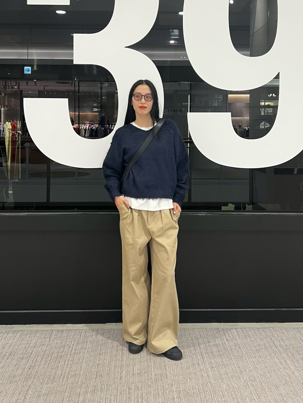 ベージュ系のその他パンツ、ブルー系のニット/セーター、ホワイト系のTシャツ/カットソーを着用したレディースの秋コーディネートの4枚目の写真