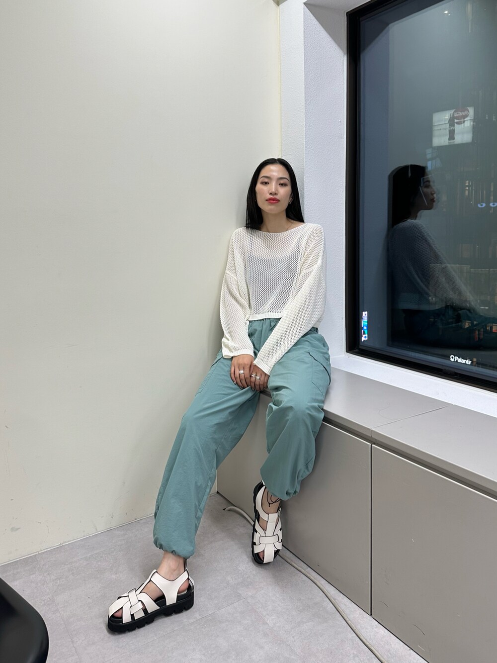グリーン系のカーゴパンツ、ホワイト系のサンダル、ホワイト系のニット/セーターを着用したレディースの春コーディネートの3枚目の写真