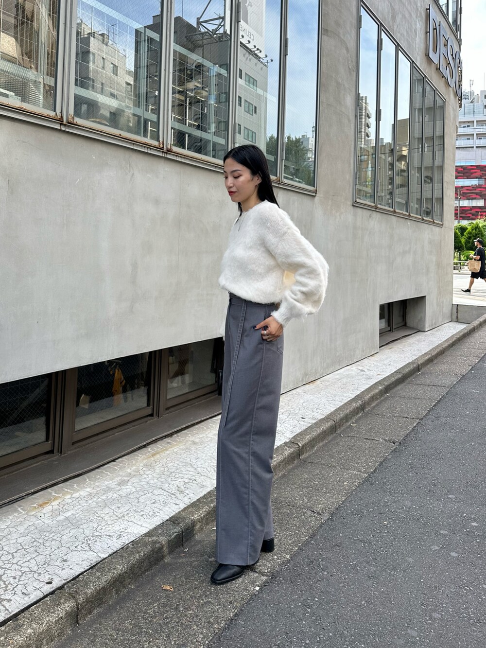 グレー系のその他パンツ、ホワイト系のニット/セーター、ブラック系のショルダーバッグを着用したレディースの秋コーディネートの2枚目の写真