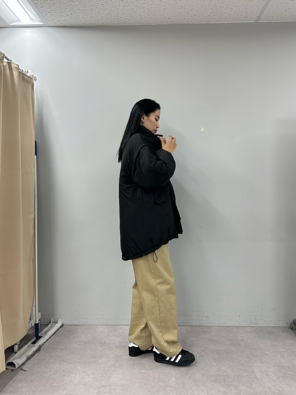 ベージュ系のその他パンツ、ブラック系のダウンジャケット/コートを着用したレディースの秋コーディネートの2枚目の写真