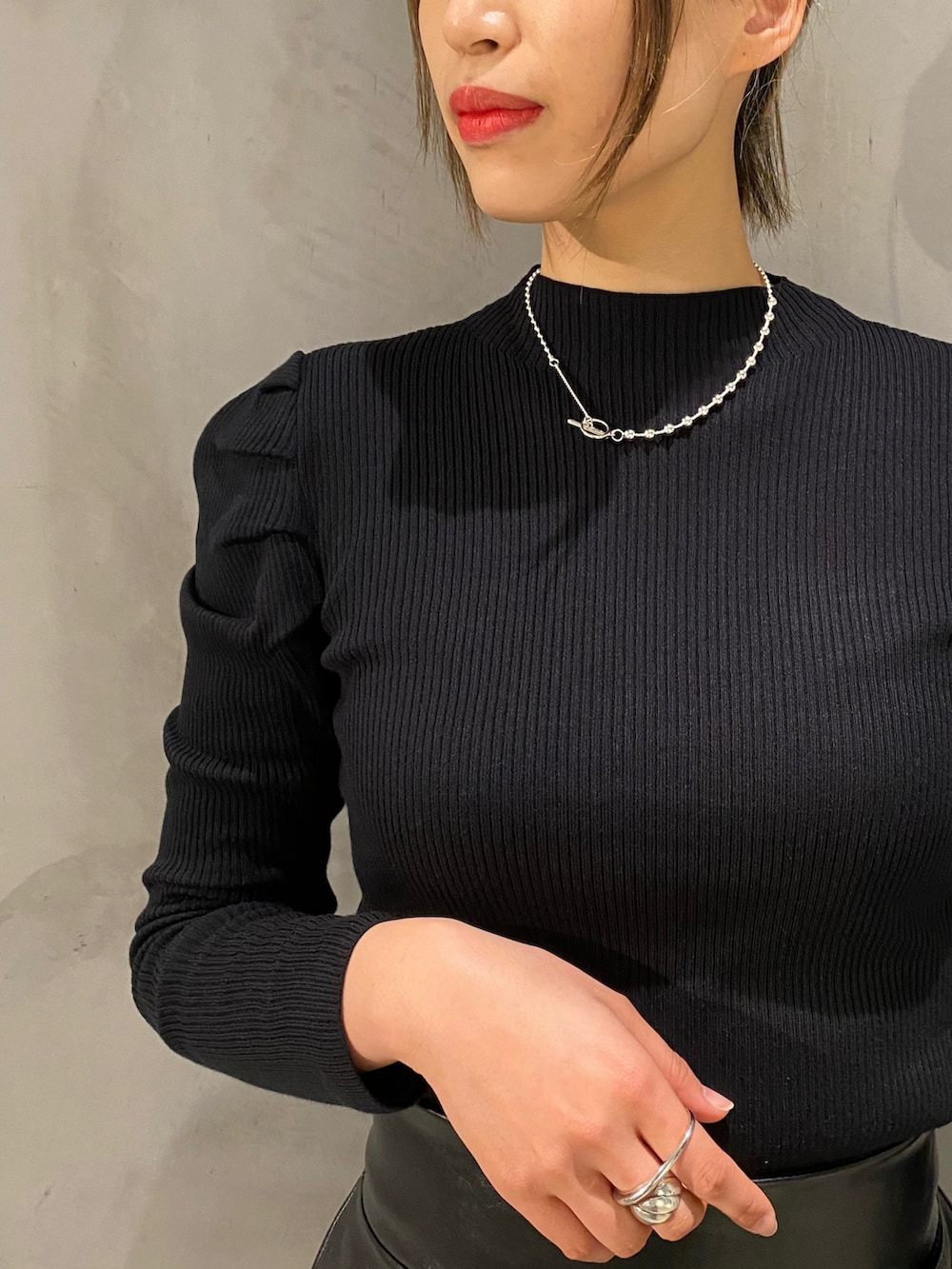 ブラック系のスカート、ブラック系のボストンバッグ、ブラック系のブーツを着用したレディースの冬コーディネートの3枚目の写真