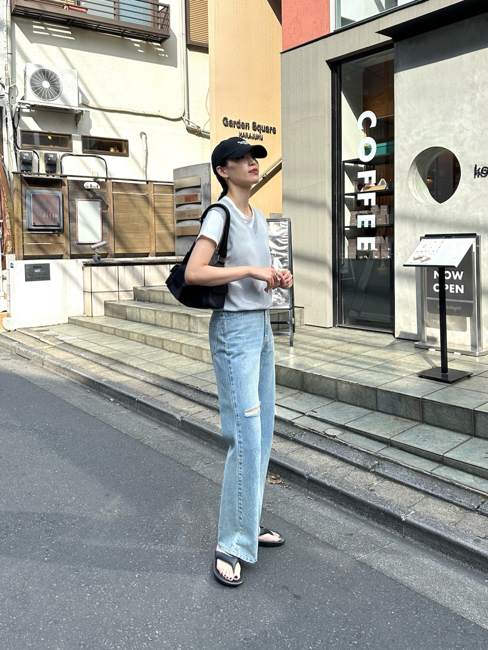 ブルー系のデニムパンツ、グレー系のベスト、ホワイト系のTシャツ/カットソーを着用したレディースの夏コーディネートの2枚目の写真