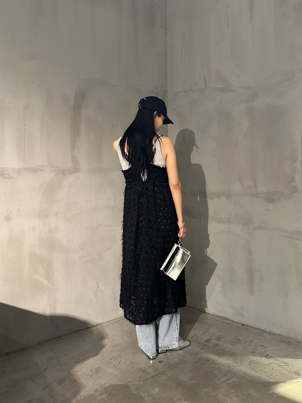 ブラック系のワンピース、グレー系のタンクトップ、ブルー系のデニムパンツを着用したレディースの夏コーディネートの3枚目の写真