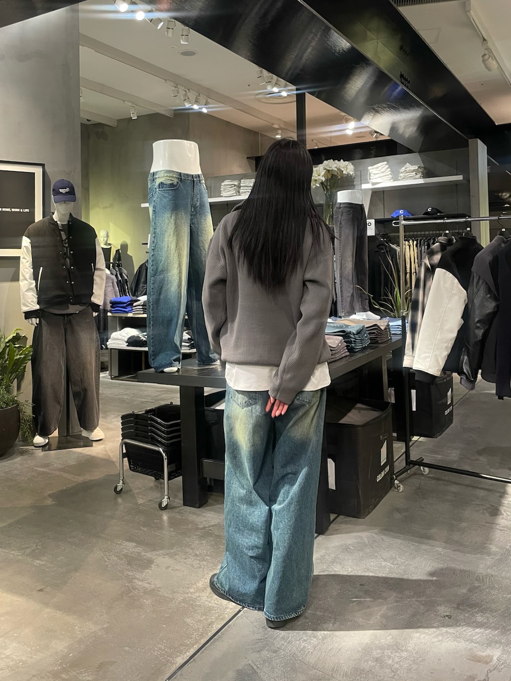 グレー系のニット/セーター、ホワイト系のTシャツ/カットソー、ブルー系のデニムパンツを着用したレディースの冬コーディネートの3枚目の写真