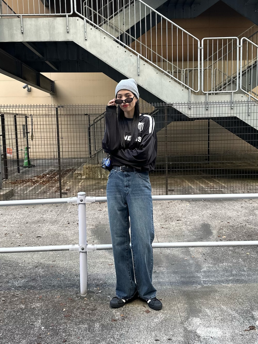 ブルー系のデニムパンツ、ブラック系のTシャツ/カットソー、グレー系のニットキャップ/ビーニーを着用したレディースの秋コーディネートの2枚目の写真