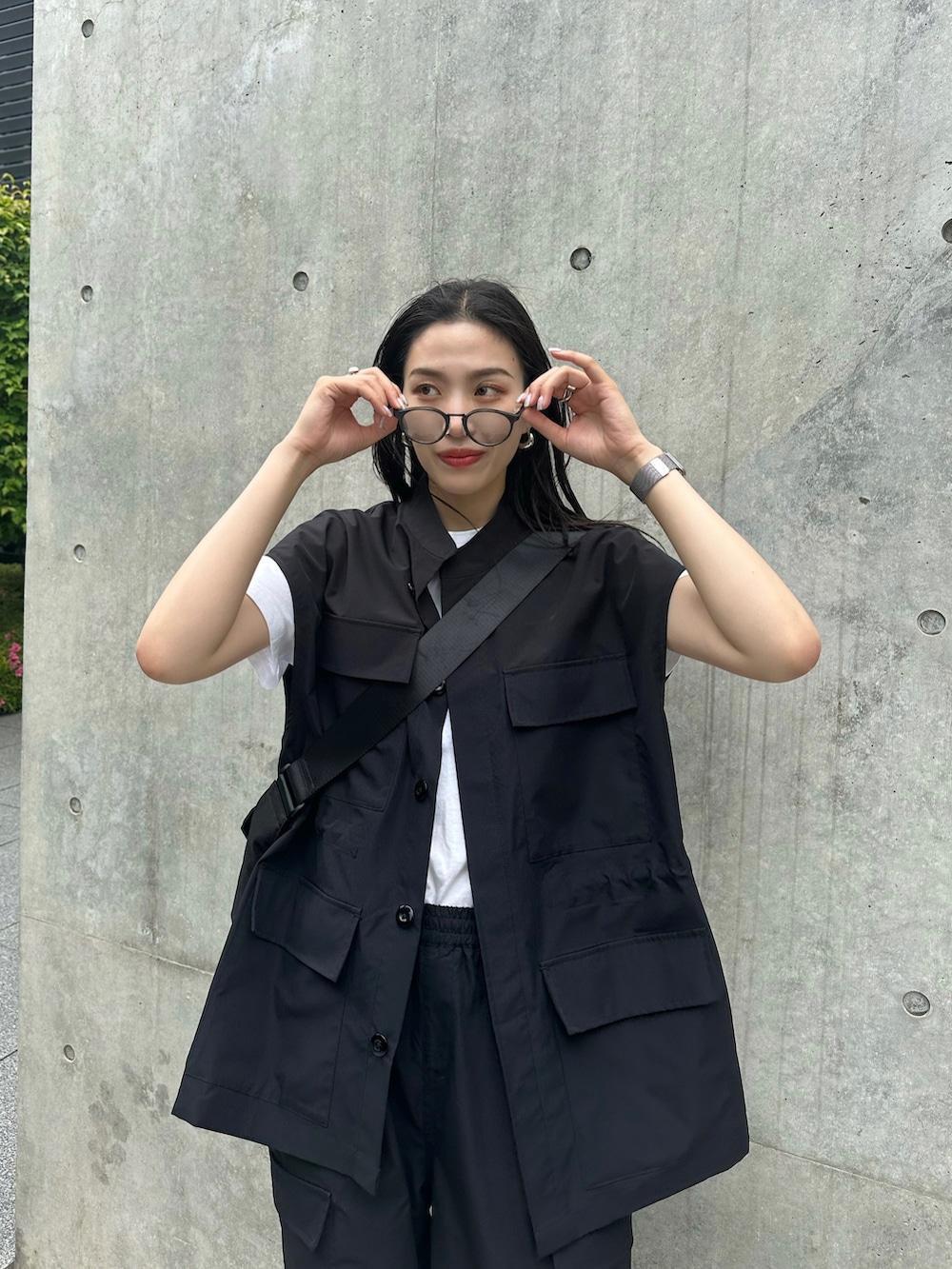 ブラック系のベストを着用したレディースの春コーディネートの3枚目の写真