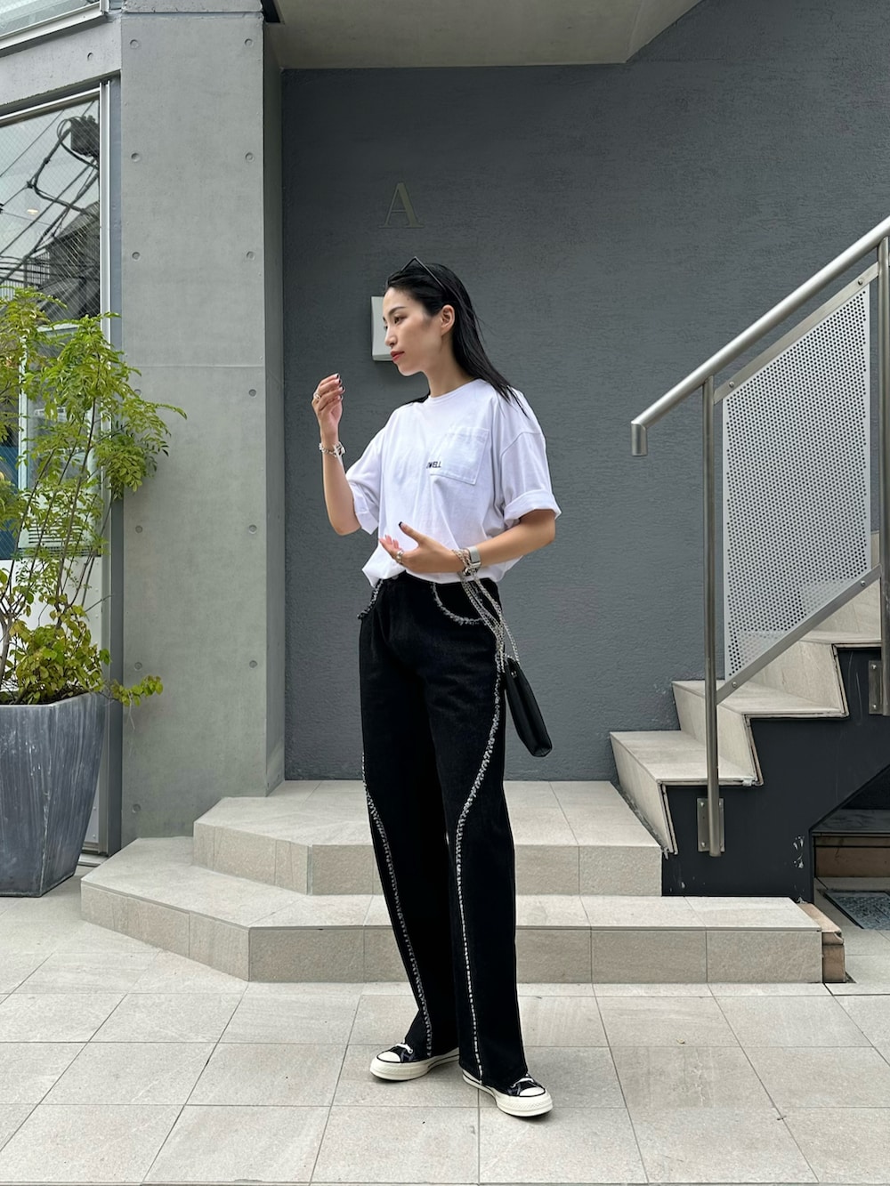 ホワイト系のTシャツ/カットソー、ブラック系のデニムパンツ、ブラック系のショルダーバッグを着用したレディースの夏コーディネートの2枚目の写真