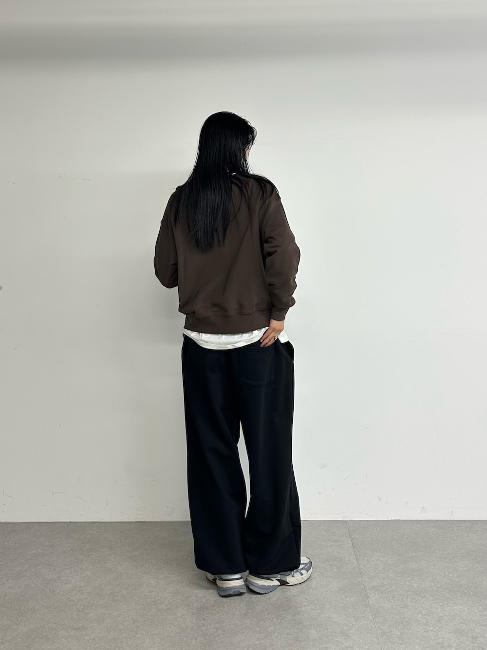 ブラウン系のスウェット、ブラック系のスウェットパンツを着用したレディースの冬コーディネートの2枚目の写真