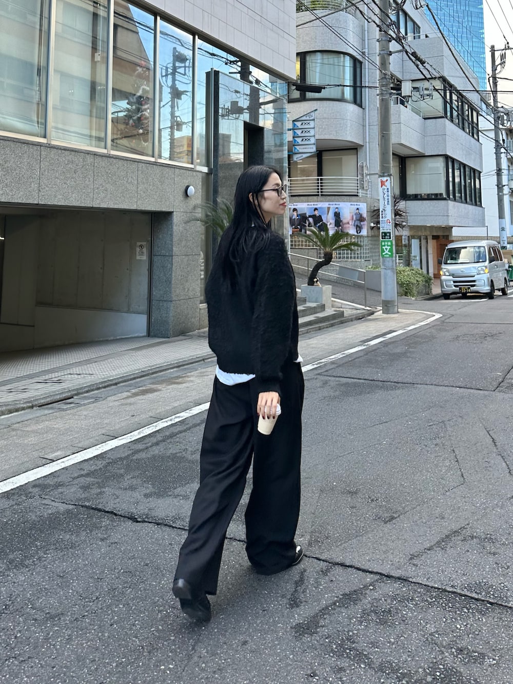 ブラック系のカーディガン/ボレロ、ホワイト系のTシャツ/カットソー、ブラック系のハンドバッグを着用したレディースの冬コーディネートの3枚目の写真