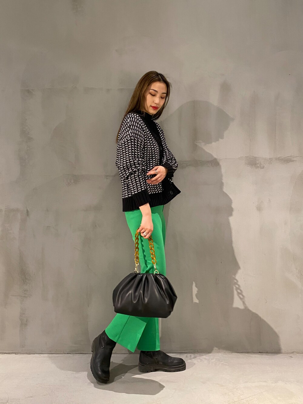 ブラック系のショルダーバッグ、グリーン系のその他パンツ、ブラック系のブーツを着用したレディースの冬コーディネートの2枚目の写真