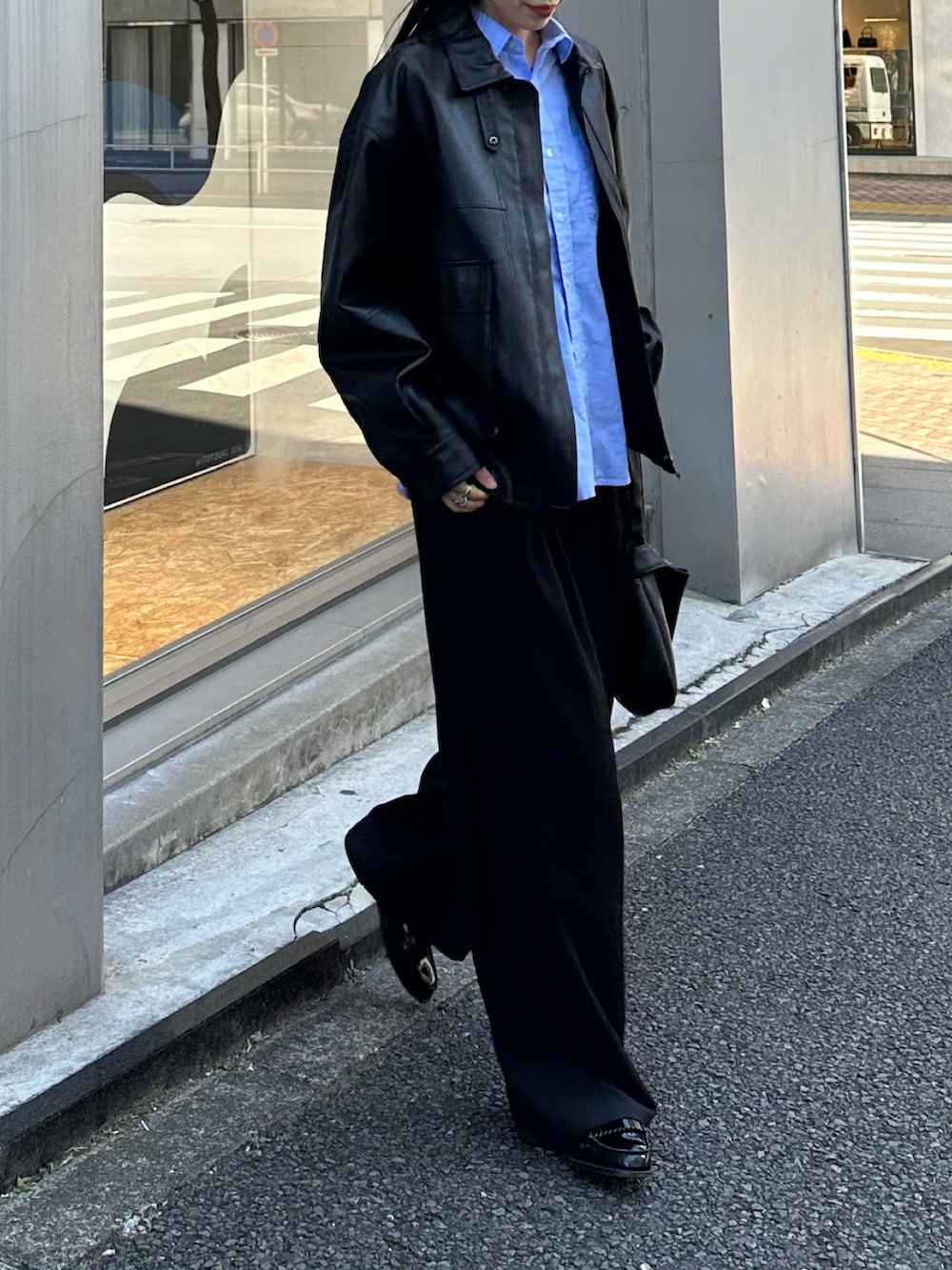 ブラック系のブルゾン、ブラック系のスラックス、ブラック系のハンドバッグを着用したレディースの冬コーディネートの2枚目の写真