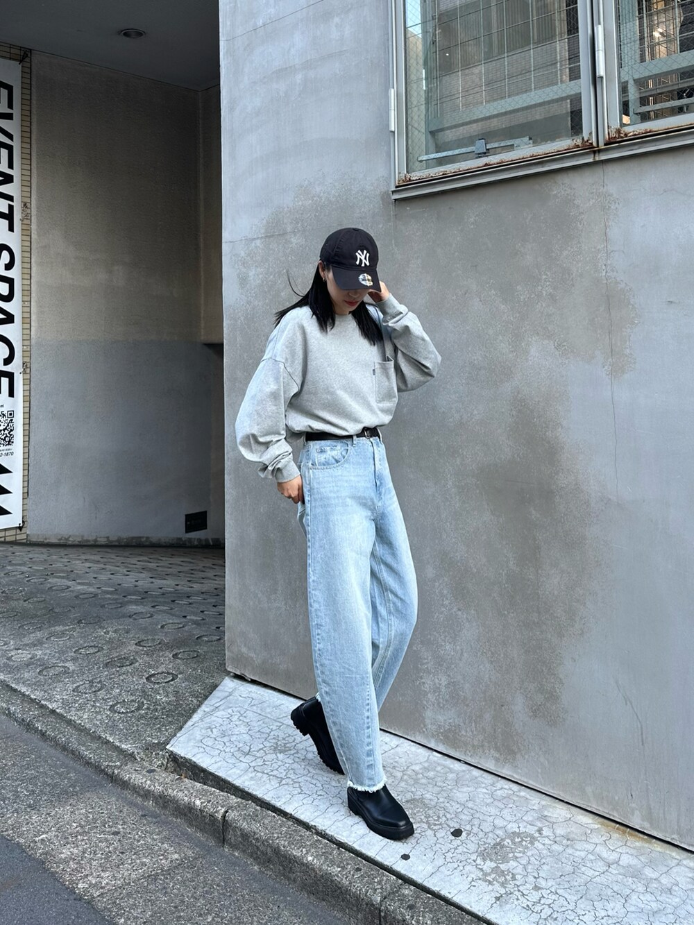 ブルー系のデニムパンツ、ブラック系のブーツ、グレー系のTシャツ/カットソーを着用したレディースの秋コーディネートの2枚目の写真