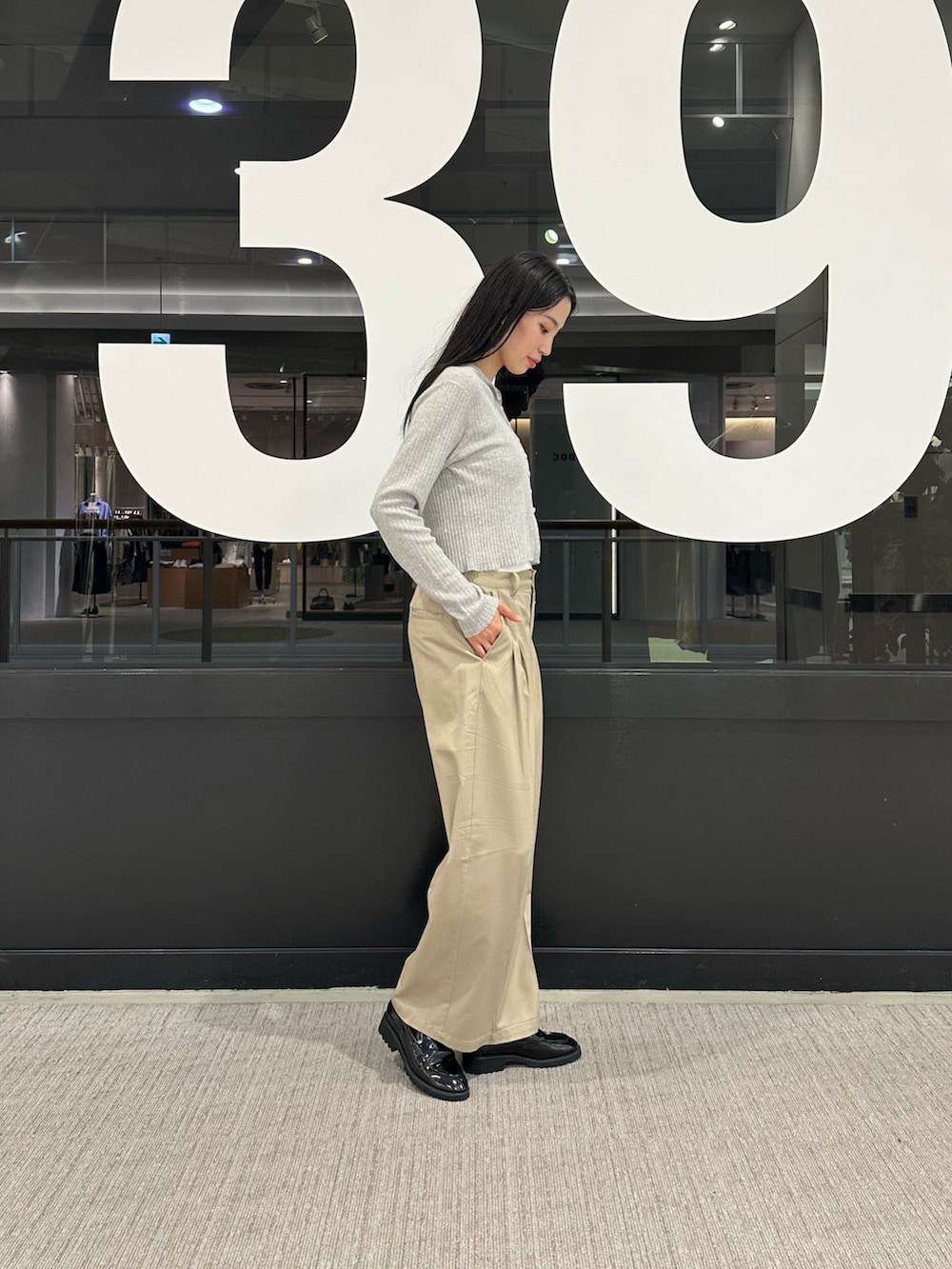 グレー系のカーディガン/ボレロ、ホワイト系のキャミソール、ベージュ系のチノパンツを着用したレディースの春コーディネートの2枚目の写真