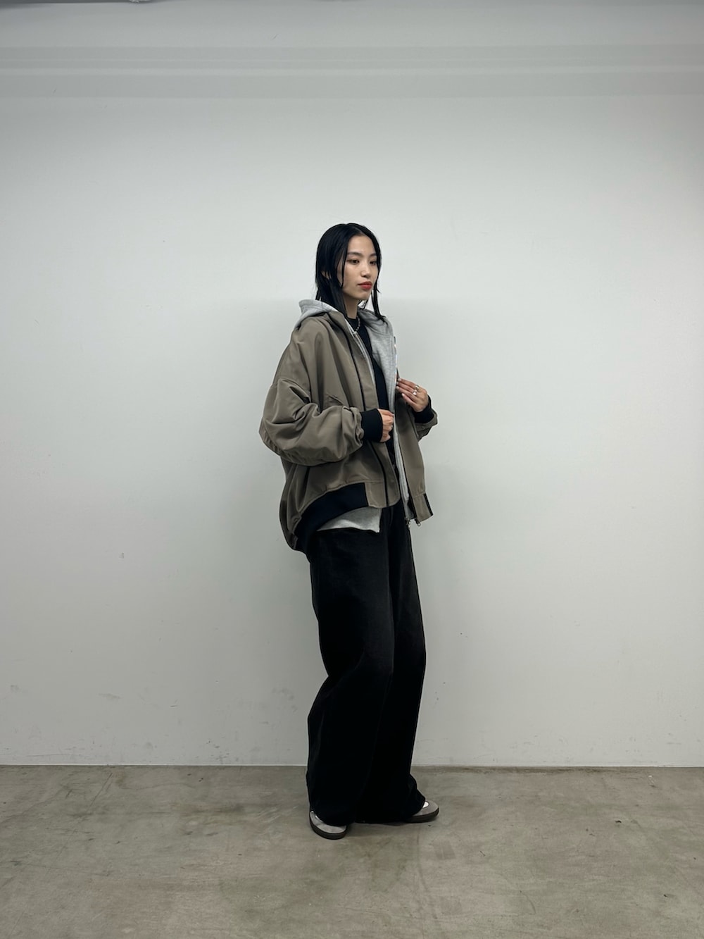 ブラック系のニット/セーター、グレー系のパーカー、ベージュ系のジャケット/アウターを着用したレディースの秋コーディネートの2枚目の写真