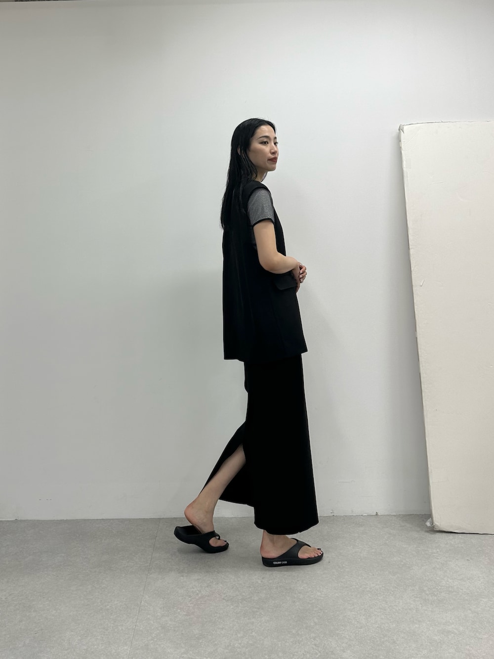 ブラック系のスカート、ブラック系のベスト、ブラック系のTシャツ/カットソーを着用したレディースの春コーディネートの2枚目の写真