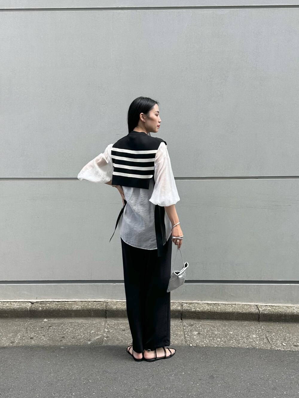 ブラック系のその他パンツ、ブラック系のサンダル、シルバー系のショルダーバッグを着用したレディースの春コーディネートの2枚目の写真