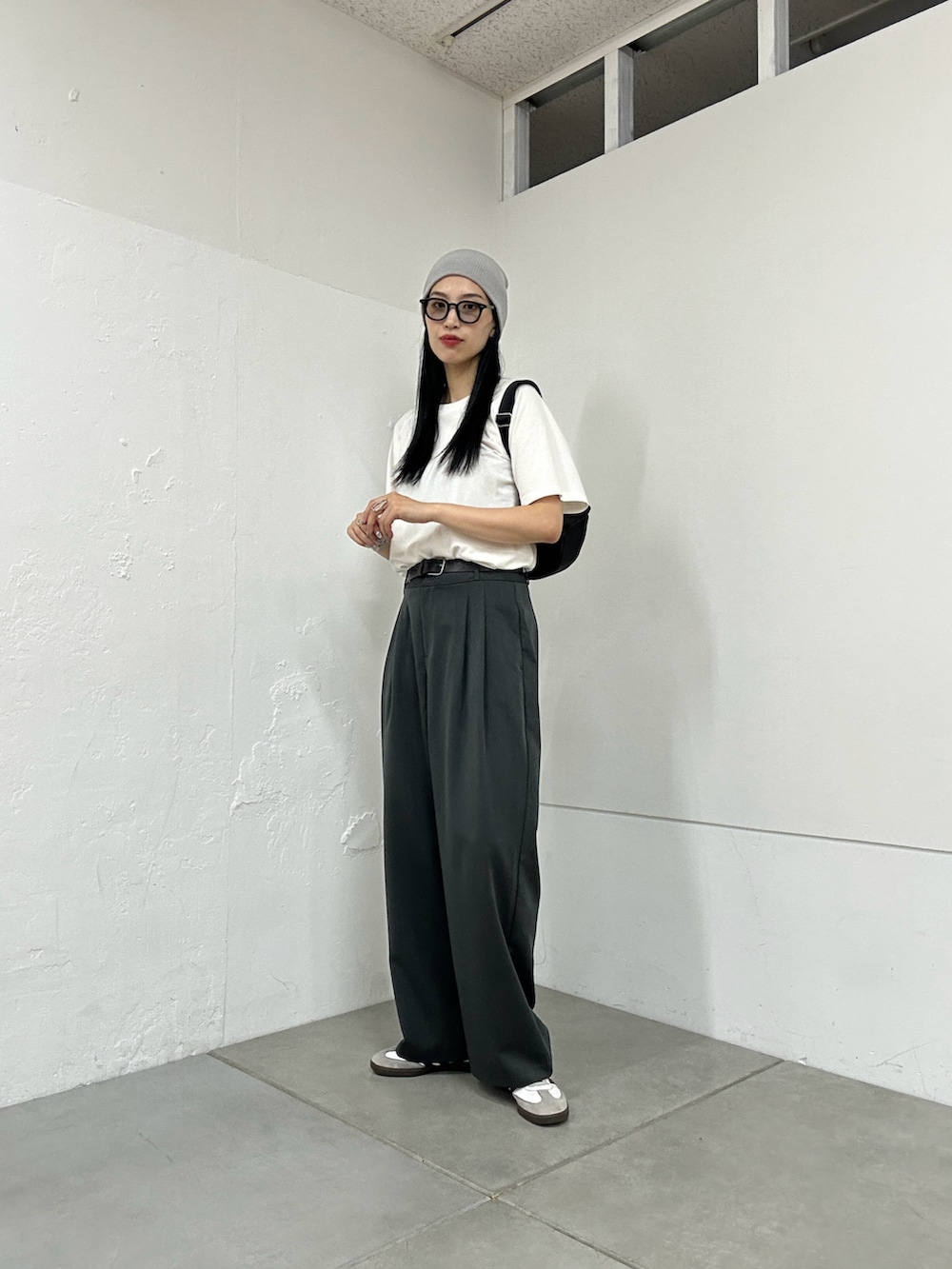 ホワイト系のTシャツ/カットソー、グレー系のスラックス、ブラック系のショルダーバッグを着用したレディースの夏コーディネートの4枚目の写真