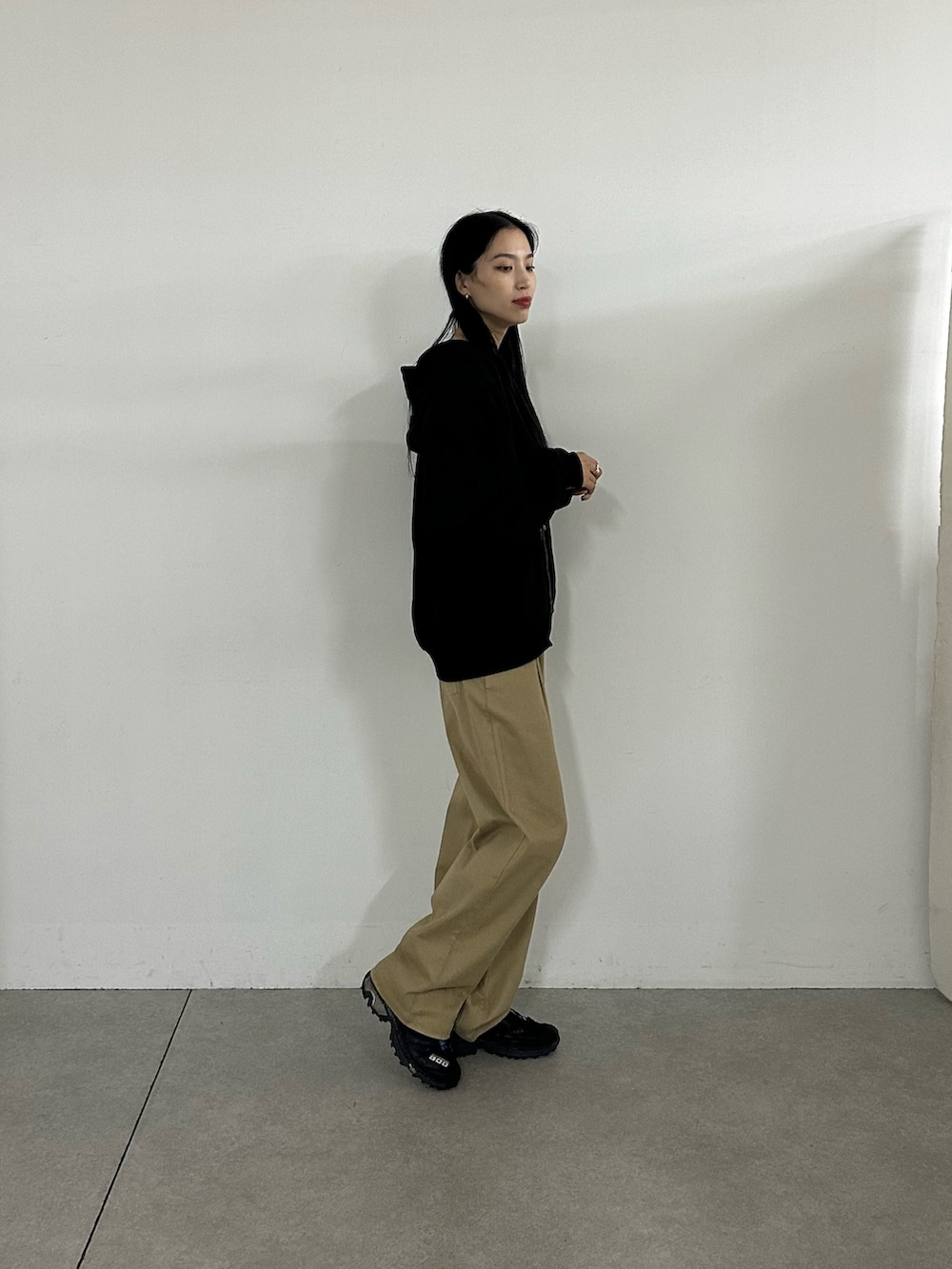 ベージュ系のその他パンツ、ブラック系のパーカーを着用したレディースの秋コーディネートの3枚目の写真