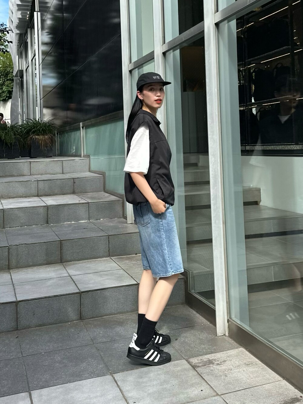 ブラック系のベスト、ホワイト系のTシャツ/カットソーを着用したレディースの夏コーディネートの2枚目の写真