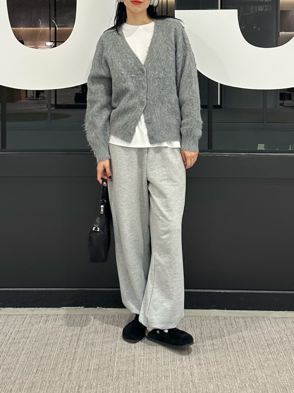 グレー系のカーディガン/ボレロ、ホワイト系のTシャツ/カットソー、グレー系のスウェットパンツを着用したレディースの冬コーディネートの4枚目の写真