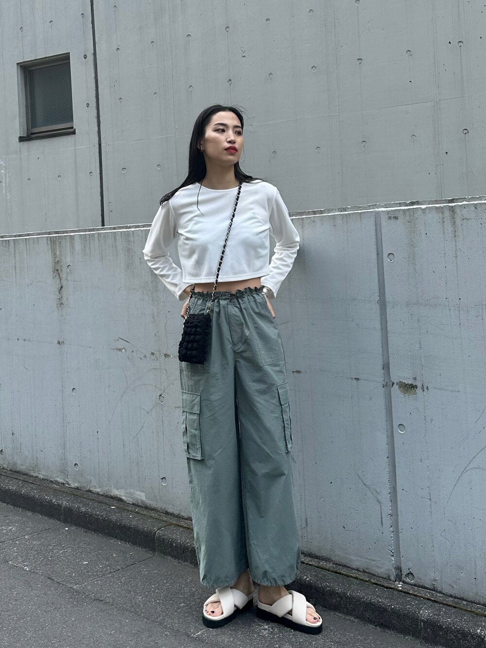 グリーン系のカーゴパンツ、ホワイト系のサンダル、ホワイト系のカーディガン/ボレロを着用したレディースの春コーディネートの2枚目の写真