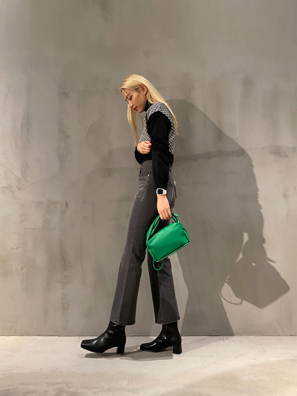 グリーン系のショルダーバッグ、グレー系のその他パンツ、ブラック系のベストを着用したレディースの冬コーディネートの2枚目の写真