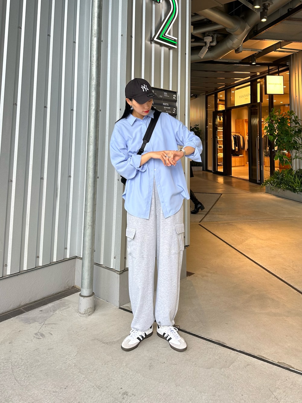 グレー系のカーゴパンツ、ブルー系のシャツ/ブラウス、ブラック系のショルダーバッグを着用したレディースの秋コーディネートの2枚目の写真