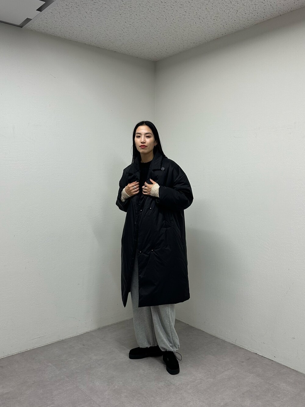 ブラック系のダウンジャケット/コート、ブラック系のニット/セーター、グレー系のカーゴパンツを着用したレディースの秋コーディネートの2枚目の写真