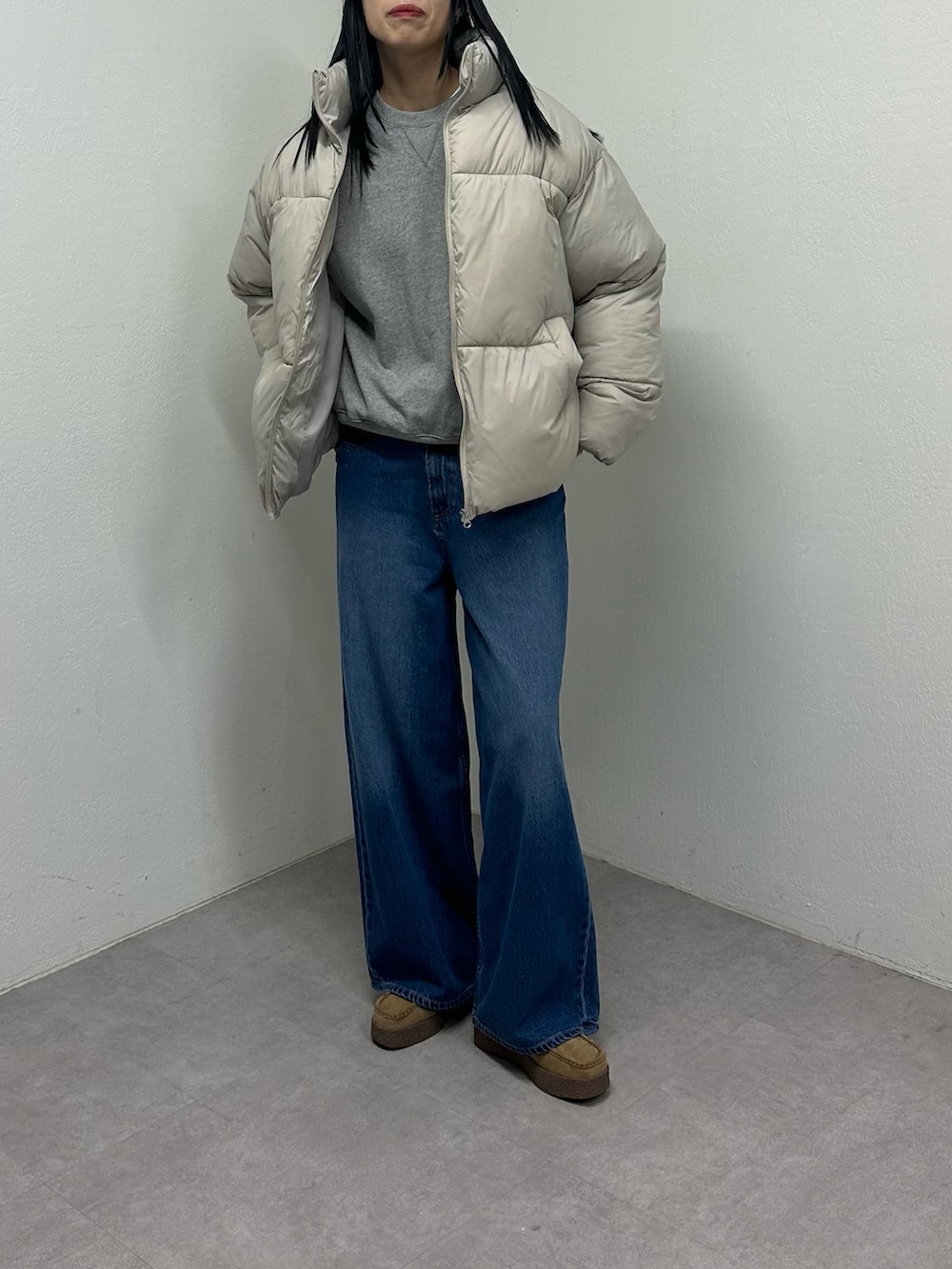 ベージュ系のダウンジャケット/コート、ブルー系のデニムパンツ、ベージュ系のモカシン/デッキシューズを着用したレディースの冬コーディネートの3枚目の写真