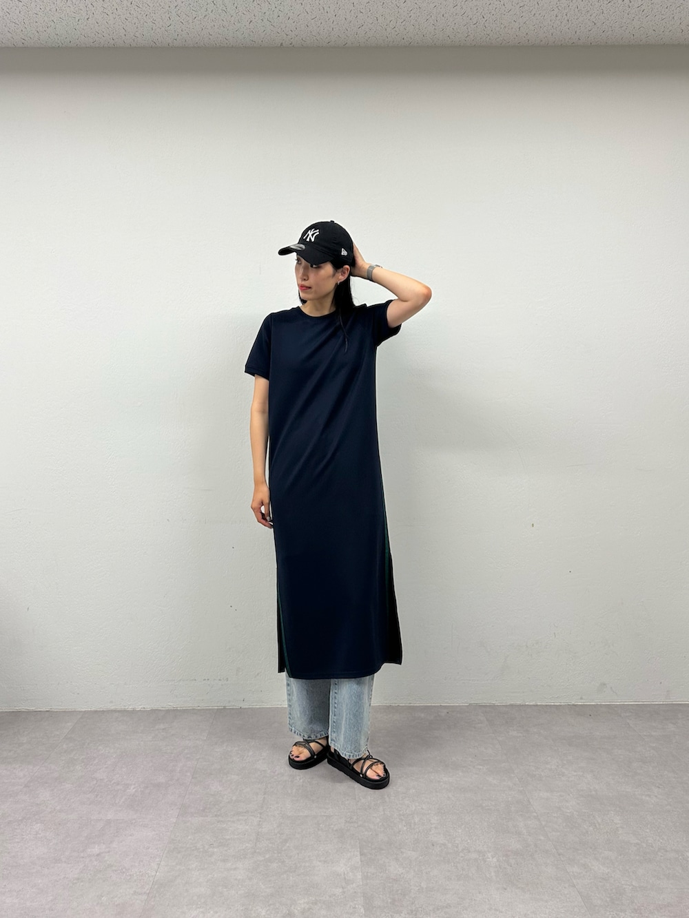 ブラック系のサンダル、ブルー系のワンピース、ブルー系のデニムパンツを着用したレディースの春コーディネートの2枚目の写真